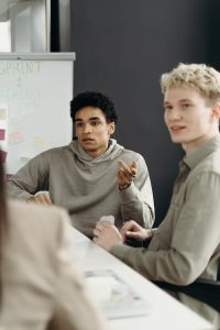 Young adults engaged in a business discussion in a modern office. Diverse team brainstorming ideas.